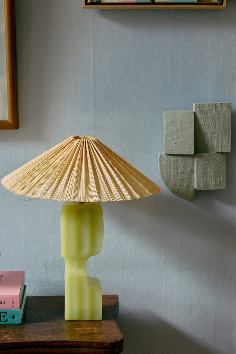 ivory HKLIVING pleated lampshade styled on a green lamp base beside textured wall decor