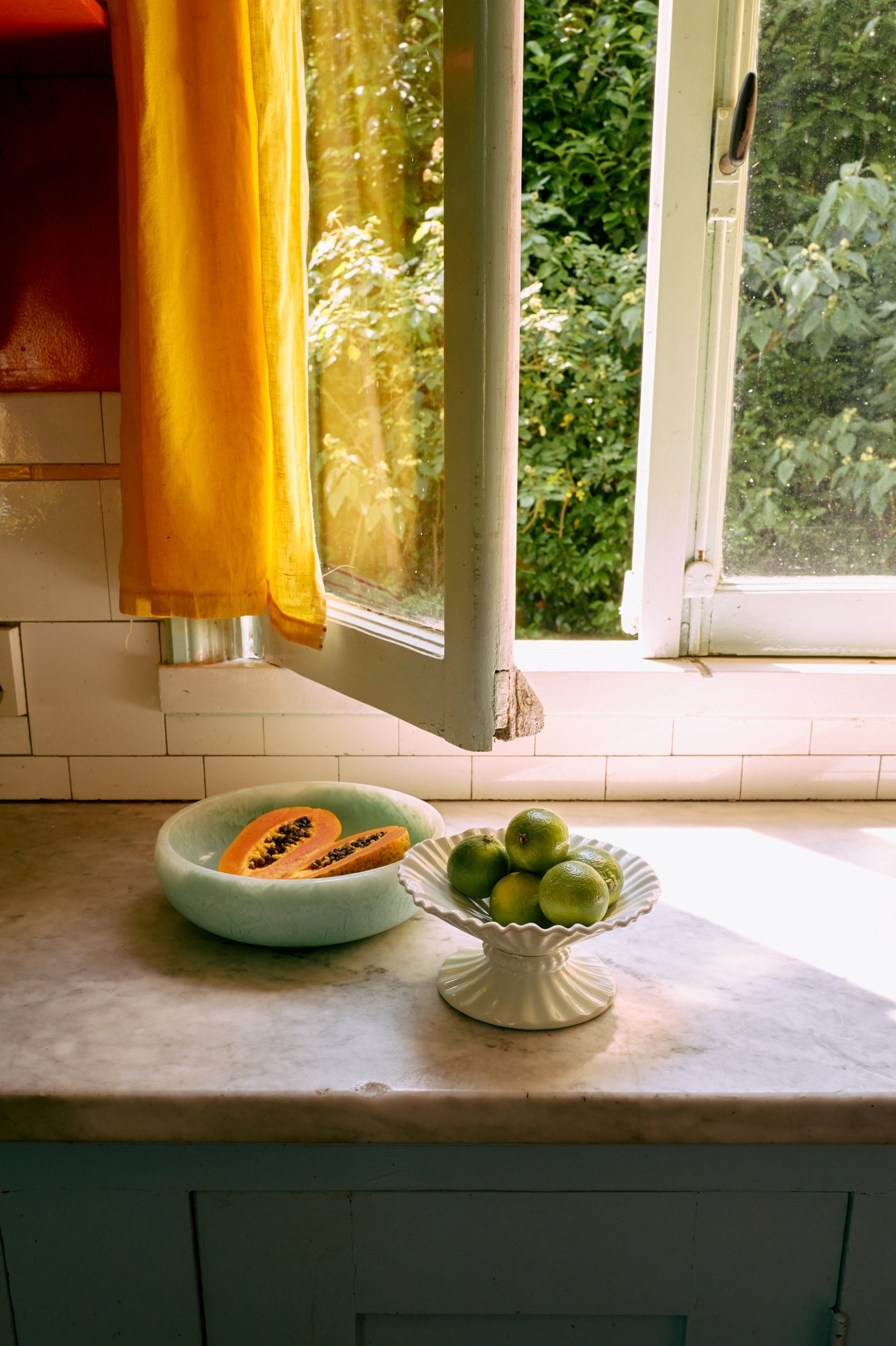 ice blue hkliving ribble bowl medium styled on marble countertop with fresh limes for calm kitchen styling
