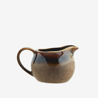 Brown ceramic milk jug on a white background