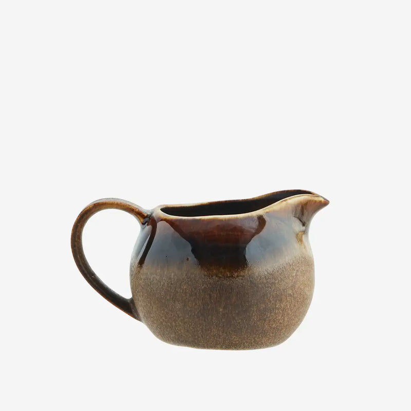 Brown ceramic milk jug on a white background