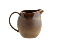 Brown ceramic pitcher on a white background
