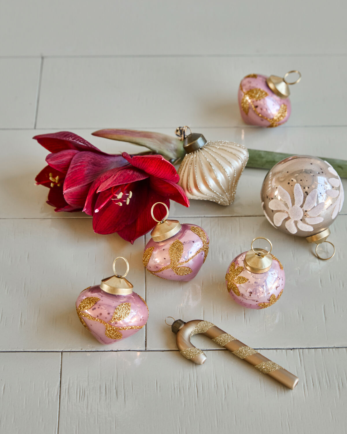 House Doctor Amore pink glass baubles on a white table with red amaryllis and other glass decorations