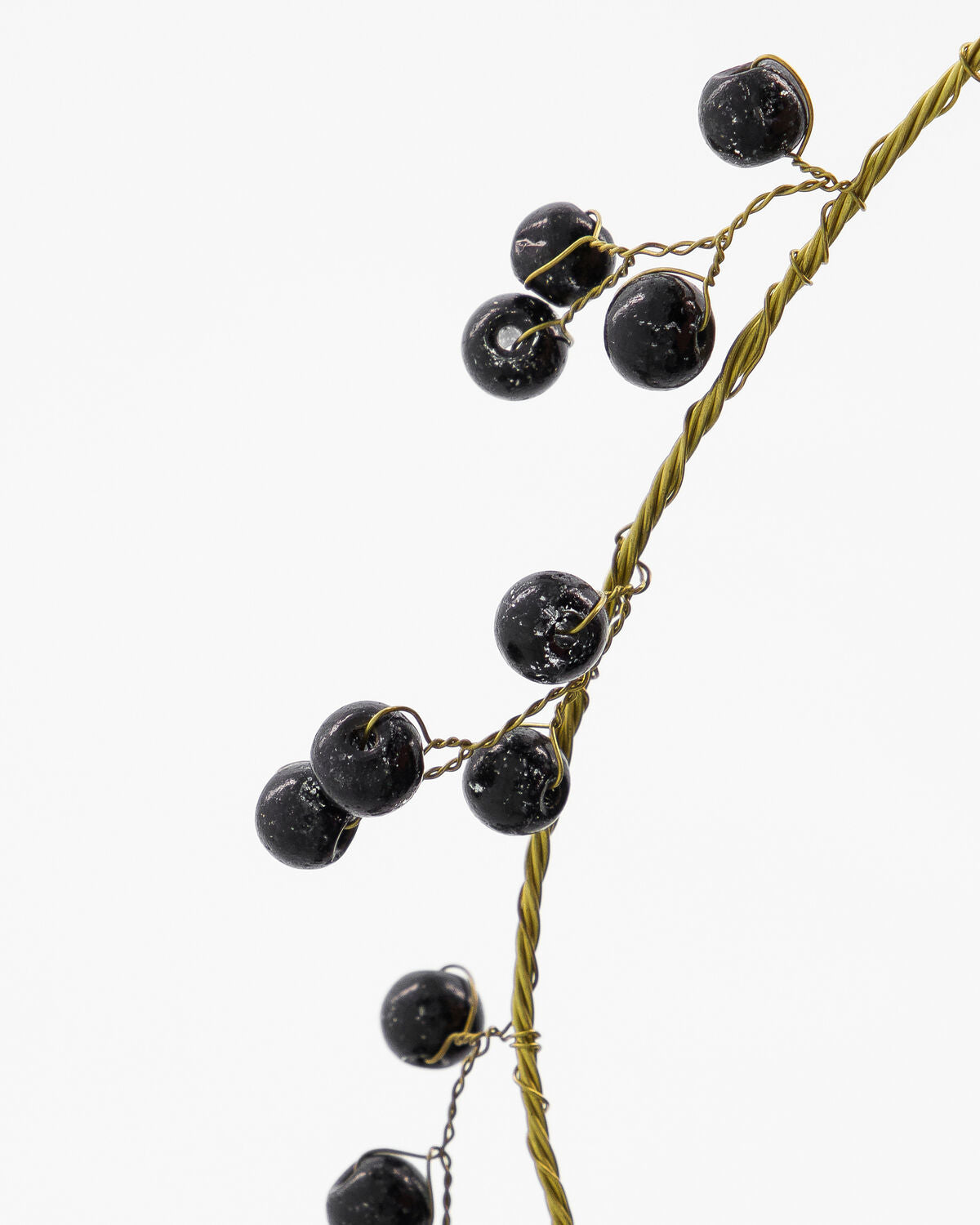 Close-up of the black glass beads on the brass ring of the House Doctor Bird decoration