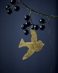 Close-up of a brass bird and black beads on the House Doctor Bird decoration