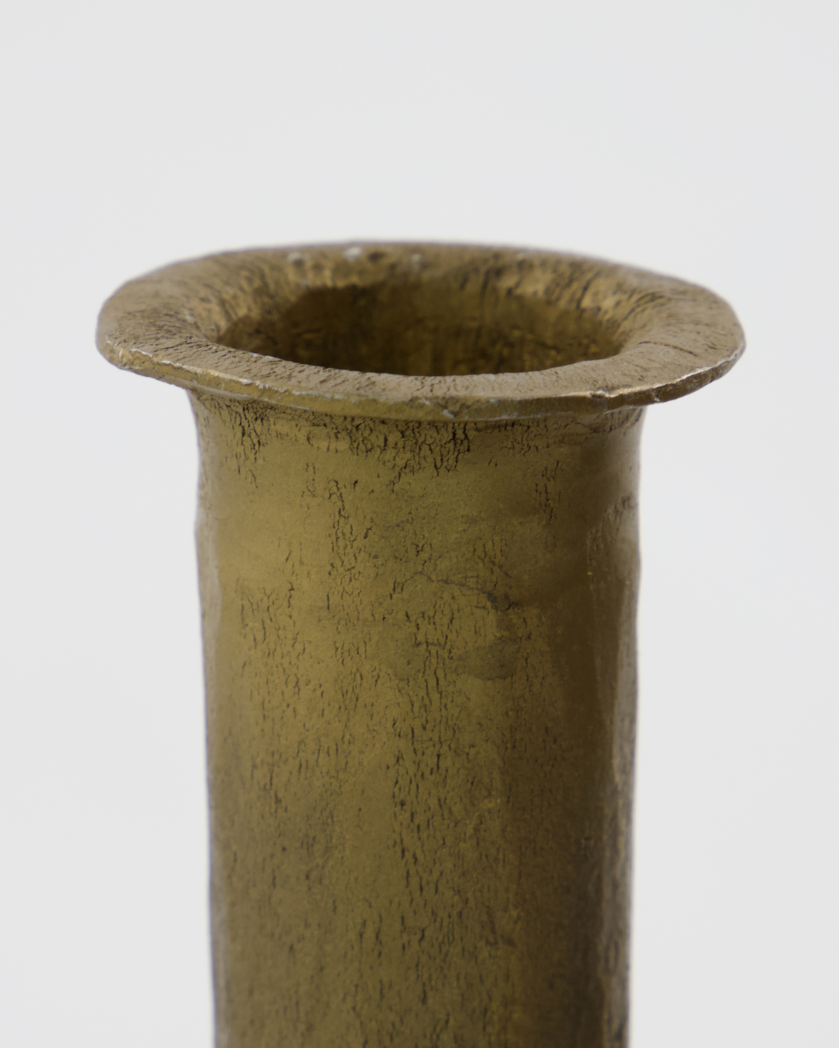 close-up of handcrafted textured antique gold candle holder with uneven rim
