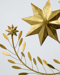 Close-up of the faceted gold star and leaf details on the House Doctor Clip tree topper