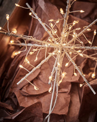 Close-up of the House Doctor Glow tree topper glowing with tiny warm LED lights