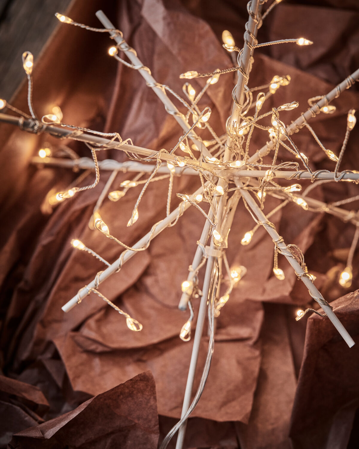 Close-up of the House Doctor Glow tree topper glowing with tiny warm LED lights