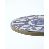 Side view of ceramic board showing hand-painted blue decoration and edge detail
