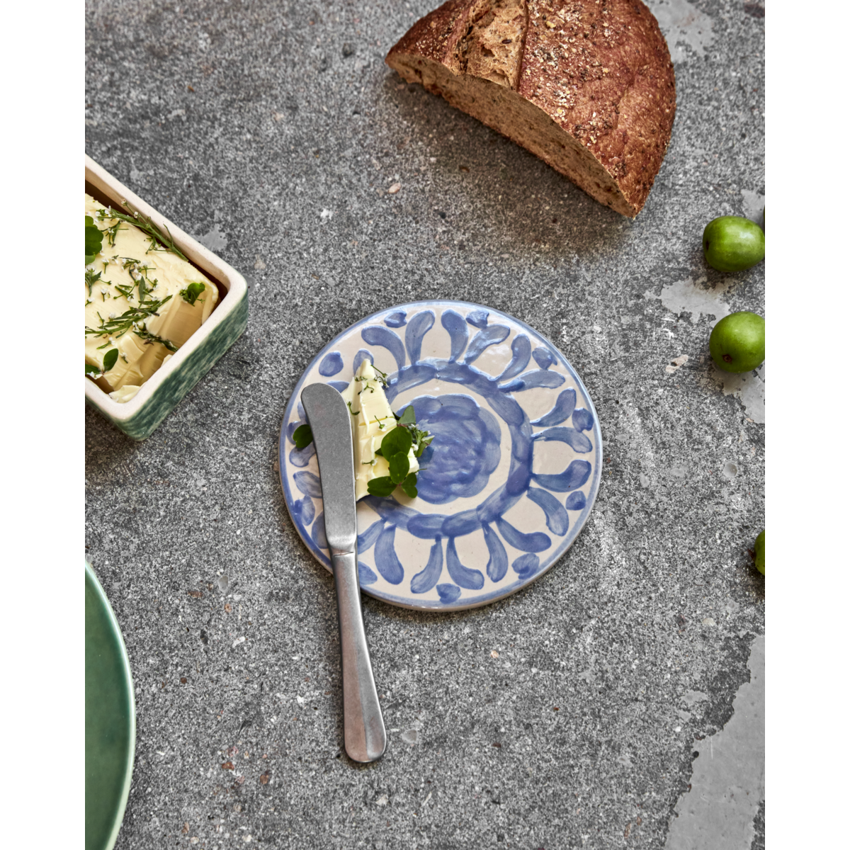 Round blue patterned ceramic board styled with butter and bread
