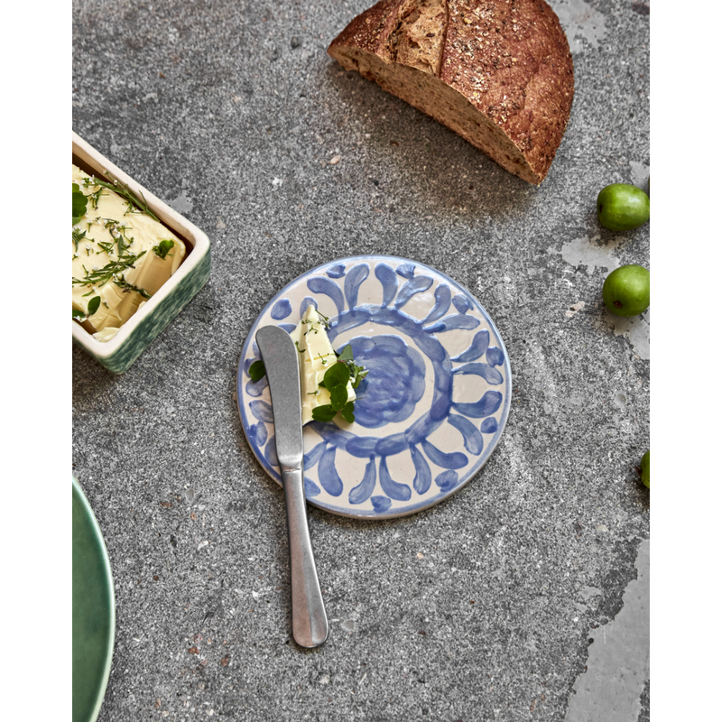 Round blue patterned ceramic board styled with butter and bread
