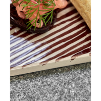 Close-up of hand-painted ceramic surface with brown diagonal lines
