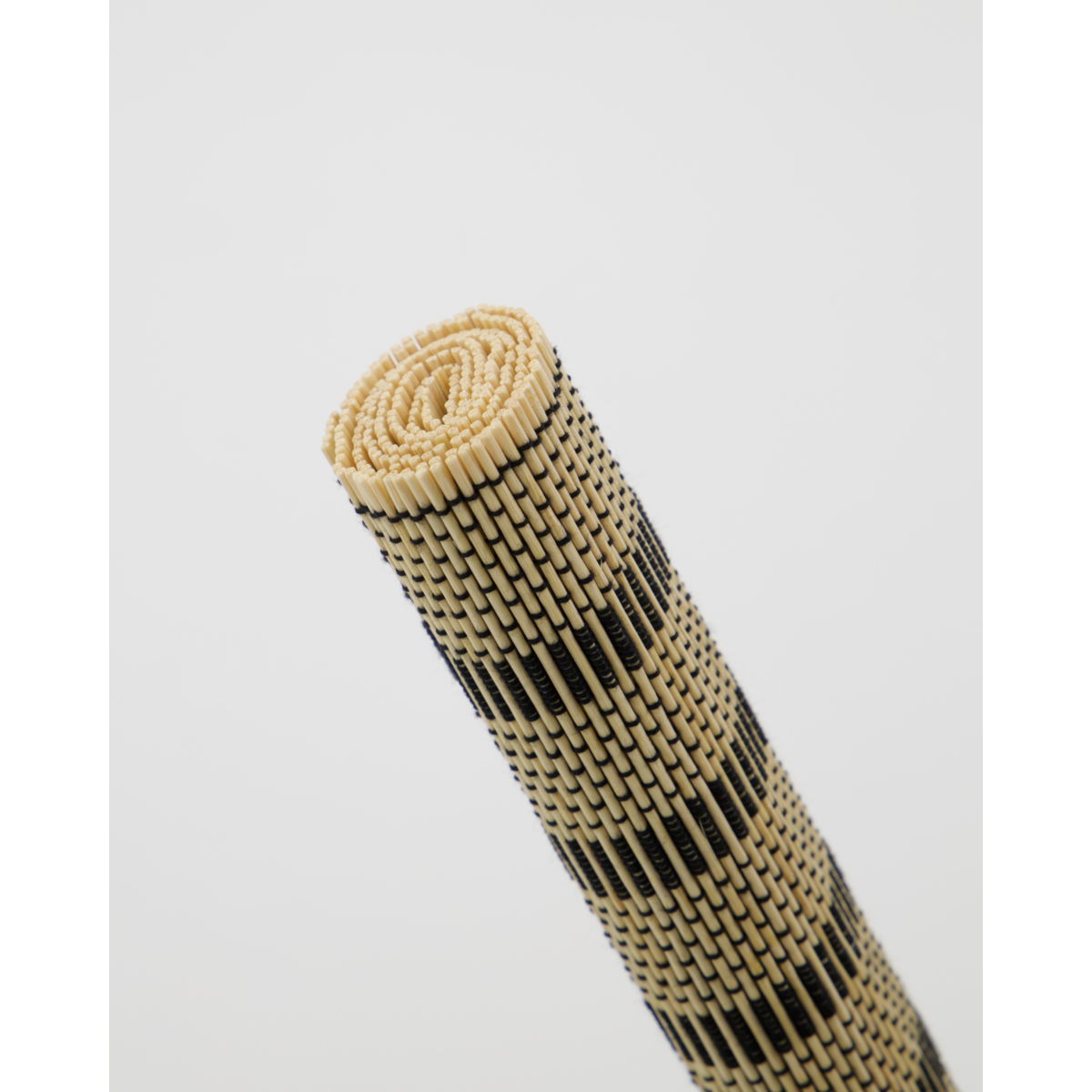Rolled black and beige table runner with striped bamboo weave
