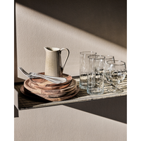 Table runner styled with wooden tableware and glassware on shelf
