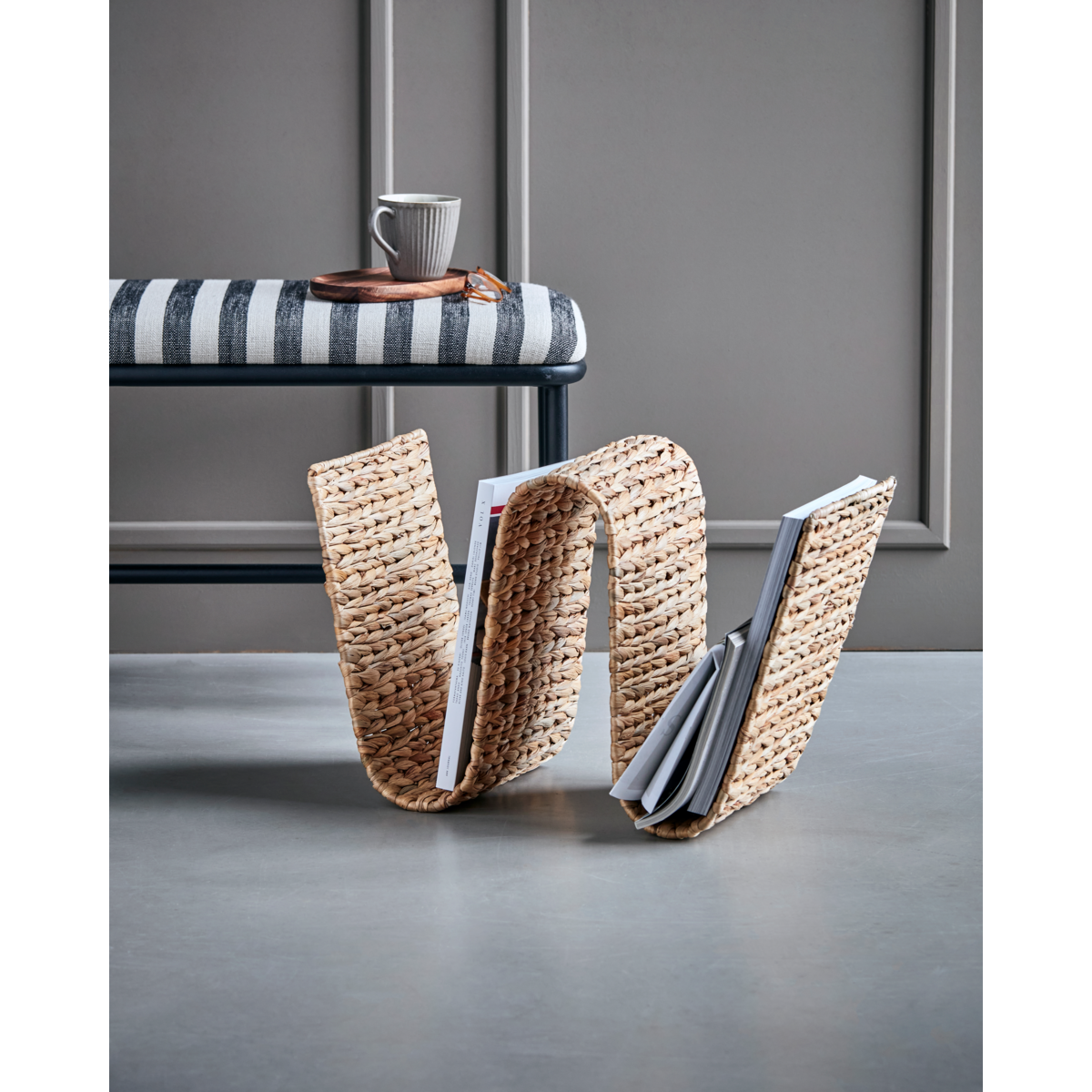 house doctor magazine rack styled under bench in modern interior
