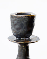 Close-up of the House Doctor Lucca candle holder's candle cup, showing the reactive black glaze with grey and brown mottling