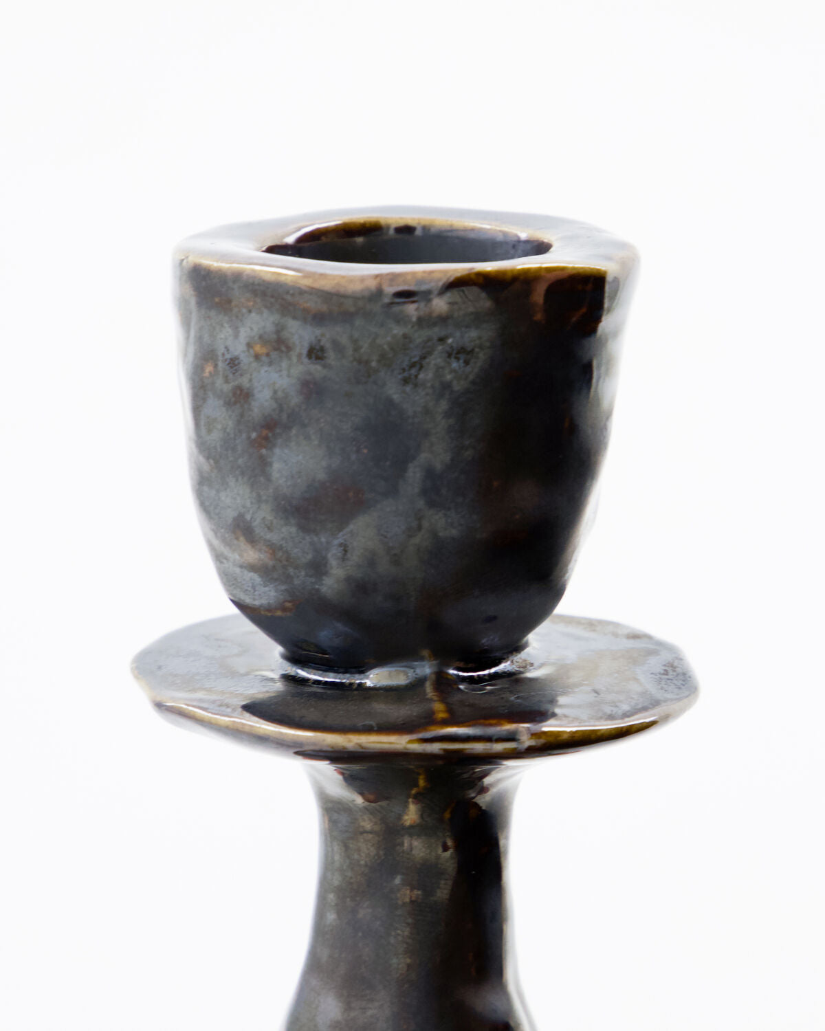 Close-up of the House Doctor Lucca candle holder's candle cup, showing the reactive black glaze with grey and brown mottling