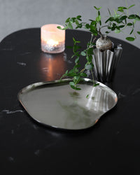 House Doctor Osea Tray, Silver Finish, styled on a dark tabletop with a lit candle and small vase