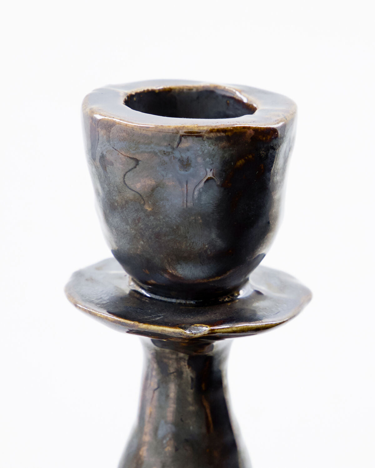 Close-up of the House Doctor Lucca candle holder's candle cup, showing the reactive black glaze with grey and brown mottling