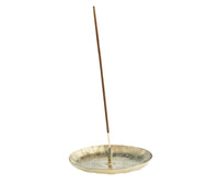close up of iron incense holder in antique brass holding incense stick

