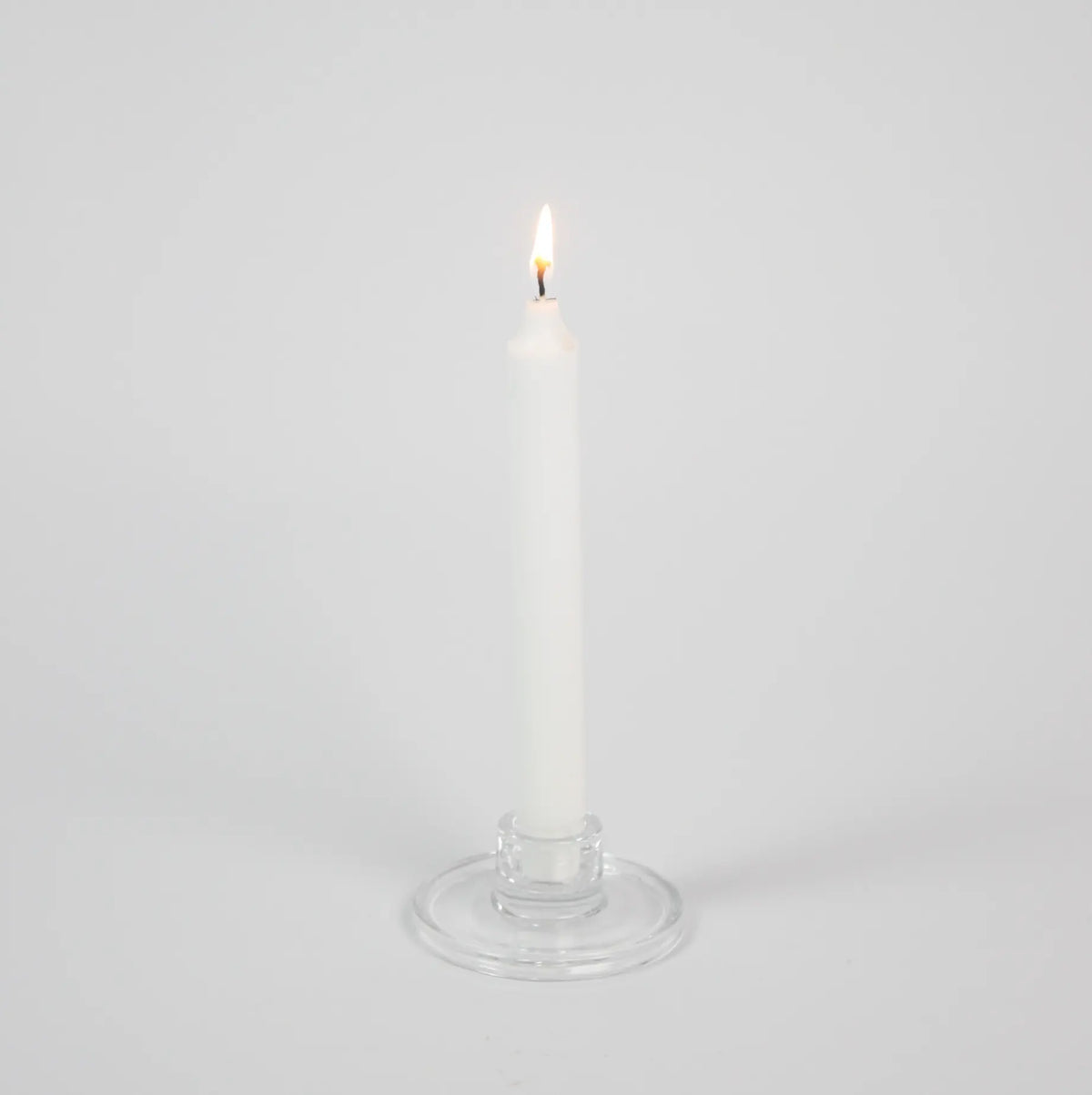 Isabella clear glass taper candle holder by Olsson & Jensen holding a white taper candle