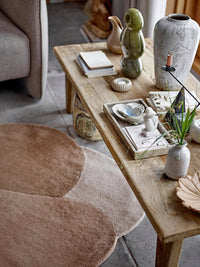 Kaui green stoneware sculpture styled on wooden table with neutral décor