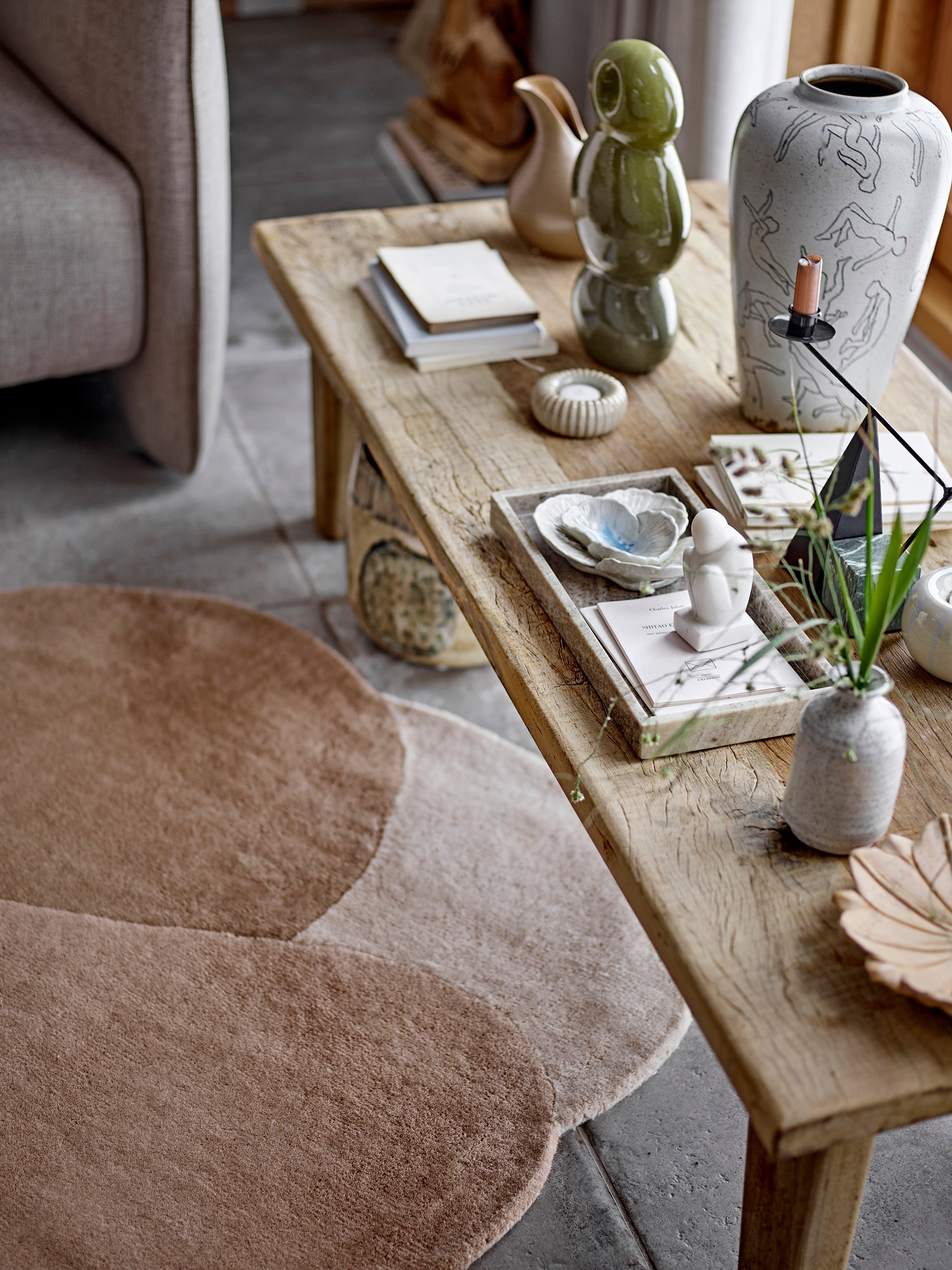 Kaui green stoneware sculpture styled on wooden table with neutral décor