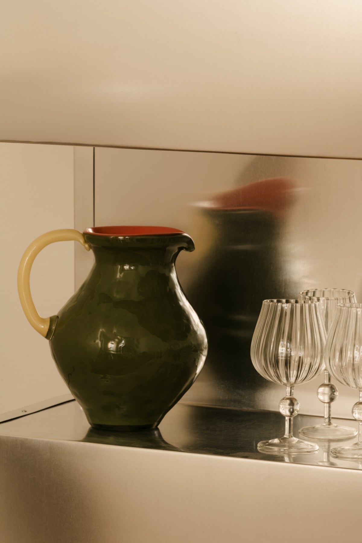Kiko green jug by Olsson & Jensen with Skye wine glasses on a mirrored shelf