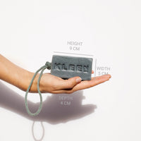 Hand holding the KLEEN Back to Life soap bar with dimensions marked to show its size