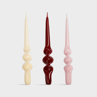 set of three &klevering candle alpha spiral tapers in cream red and pink
