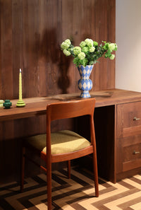 trio of green-tone &klevering candle holders with a pale yellow taper on walnut desk
