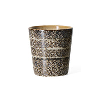 An hklvig 70s ceramic Brew coffee cup with a textured, speckled glaze in dark brown, black, and beige, featuring horizontal bands, shown on a plain white background.