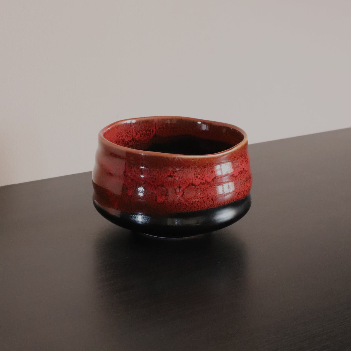 Handmade lava matcha bowl in glossy red glaze with dark base