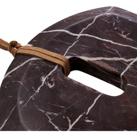 Close-up of the leather hanging strap threaded through the handle of the burgundy Marnine marble board