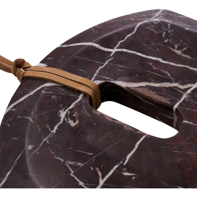 Close-up of the leather hanging strap threaded through the handle of the burgundy Marnine marble board