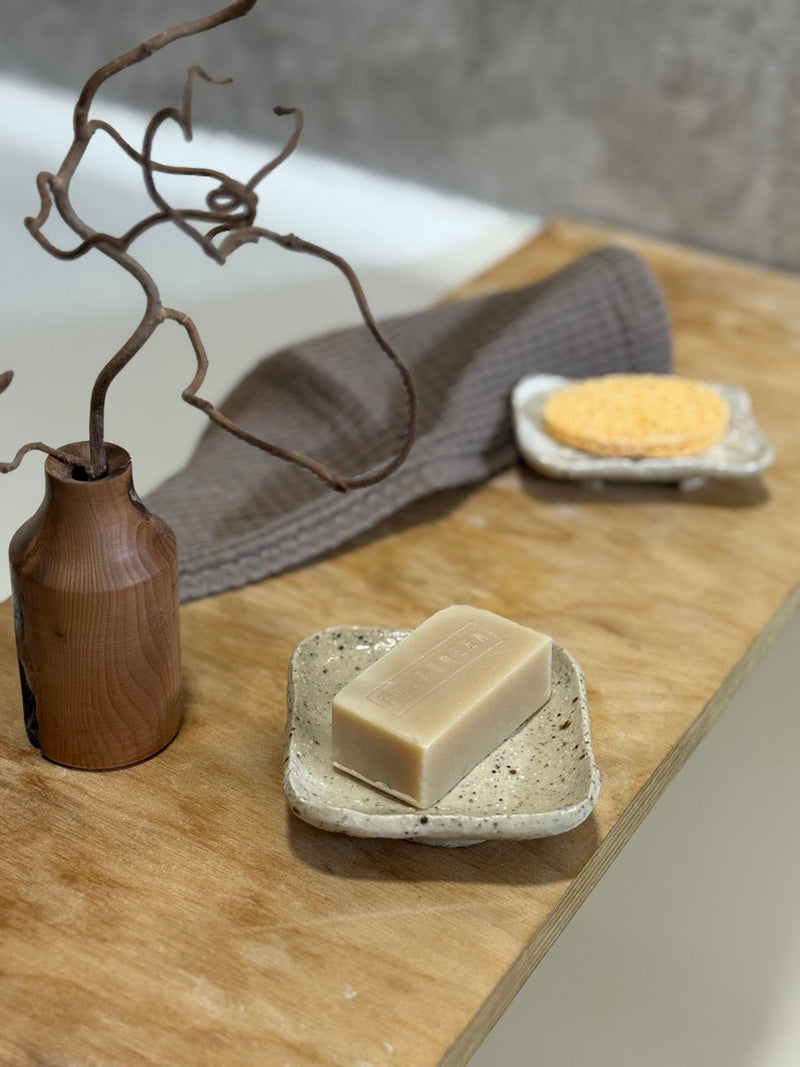 Bathroom scene with handmade ceramic soap dish and natural soap bar