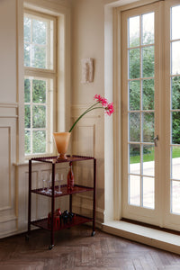 Lolli peach vase by Olsson & Jensen with a pink flower by a window