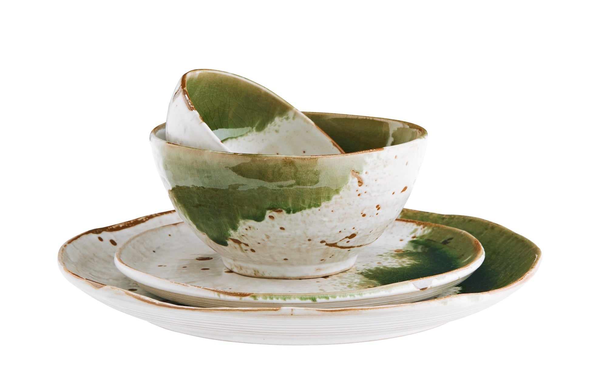 stacked small green and white stoneware bowls and plates showing artisan glaze
