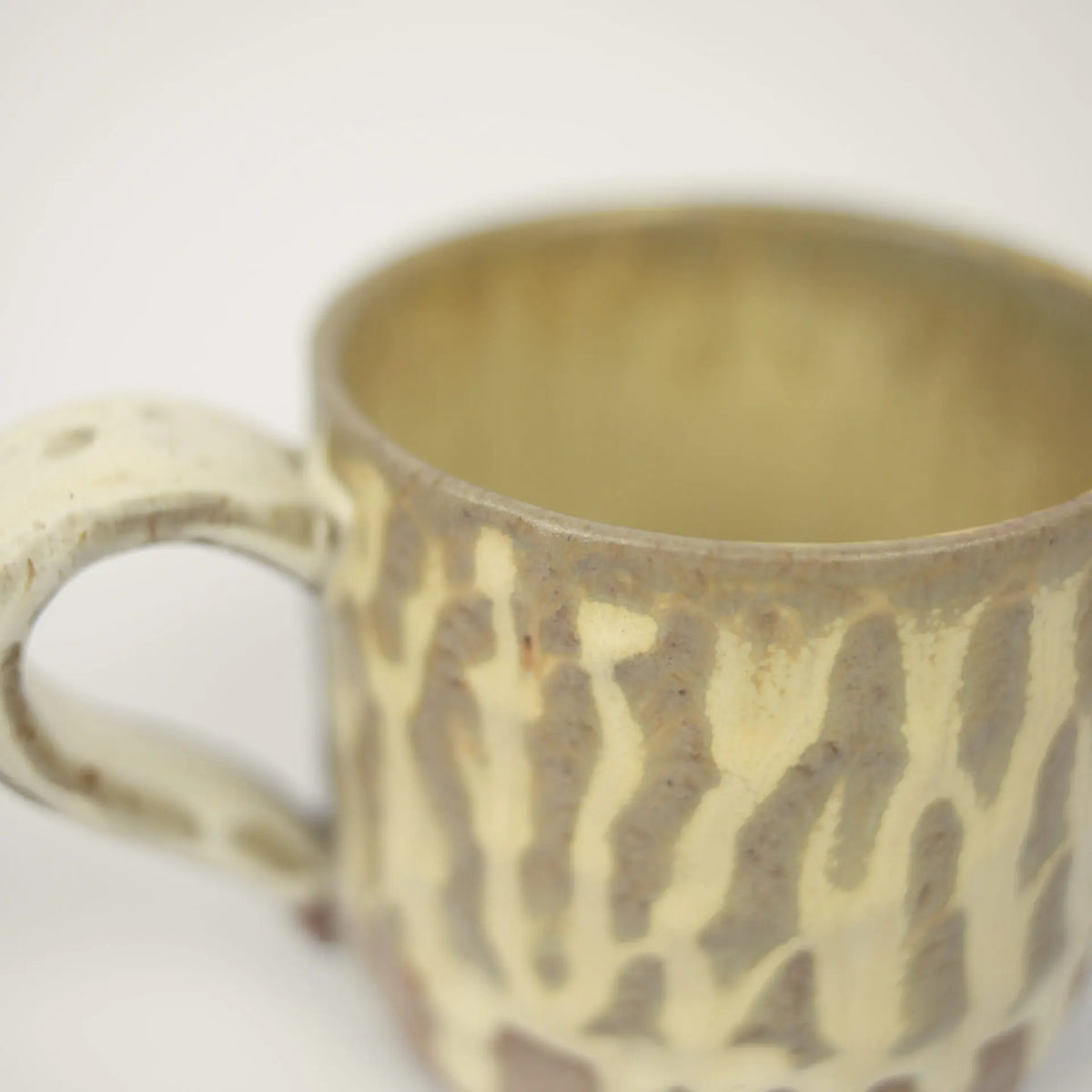 Close-up of the reactive glaze on the beige Maja mug by Olsson & Jensen