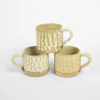 Three stacked beige Maja mugs by Olsson & Jensen