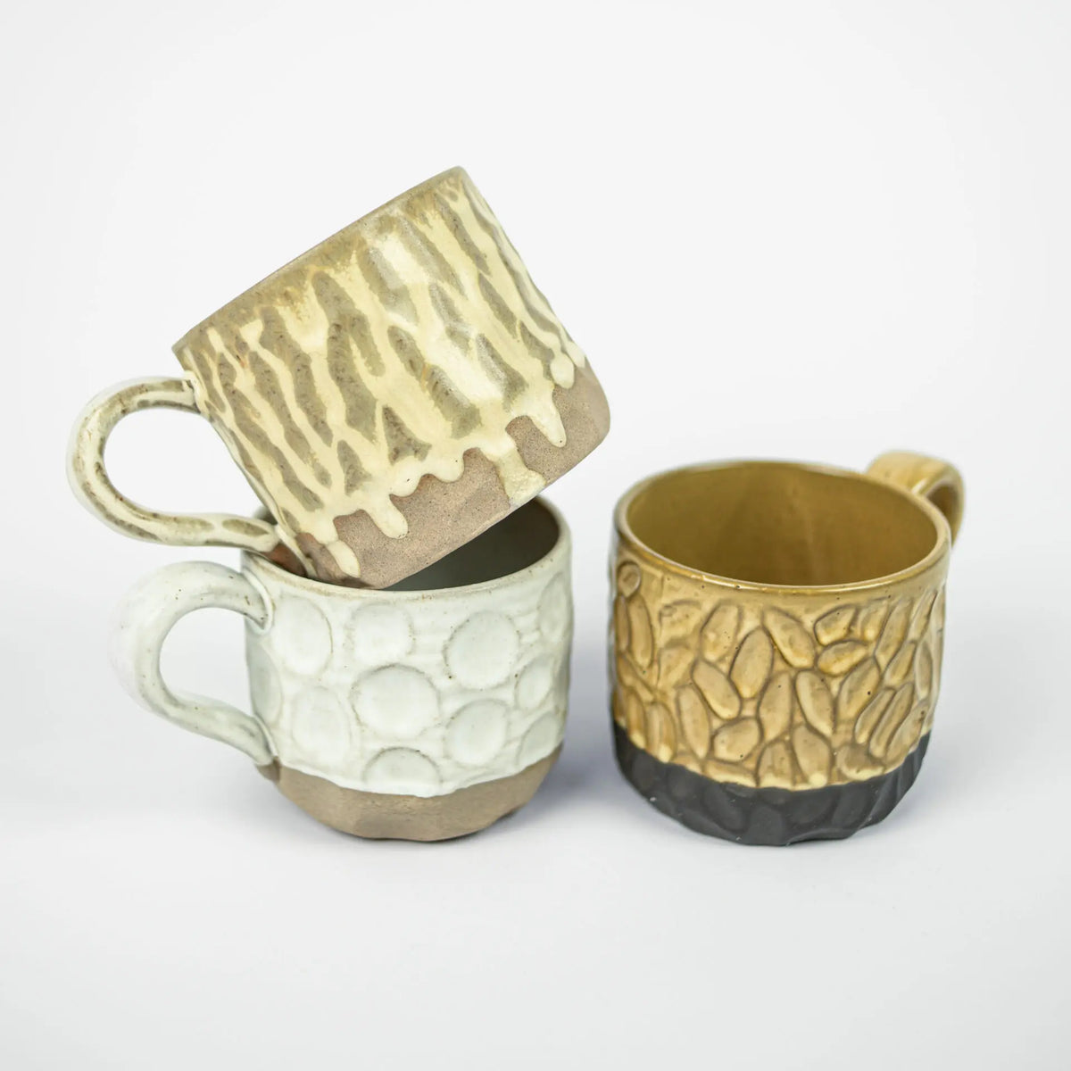 Maja ceramic mugs by Olsson & Jensen in beige, white and mustard