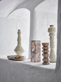 Warm brown marble votive candle holder on shelf with Nordic ceramics