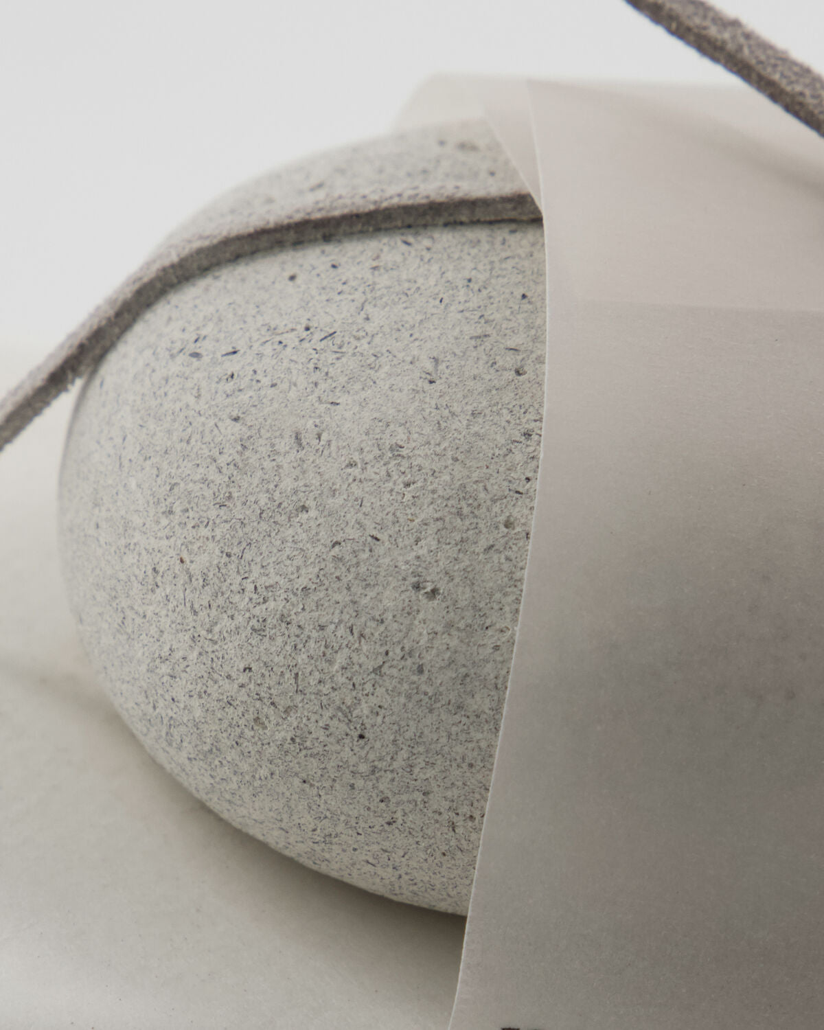 Close-up of the textured grey Meraki scrub stone and its label band