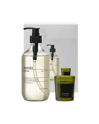 Meraki Winter Whisp hand soap pump bottle and Winter Woods scented candle in green glass beside the box