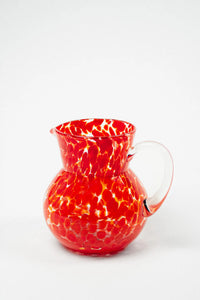 Milano red speckled hand-blown glass jug by Olsson & Jensen on a white background