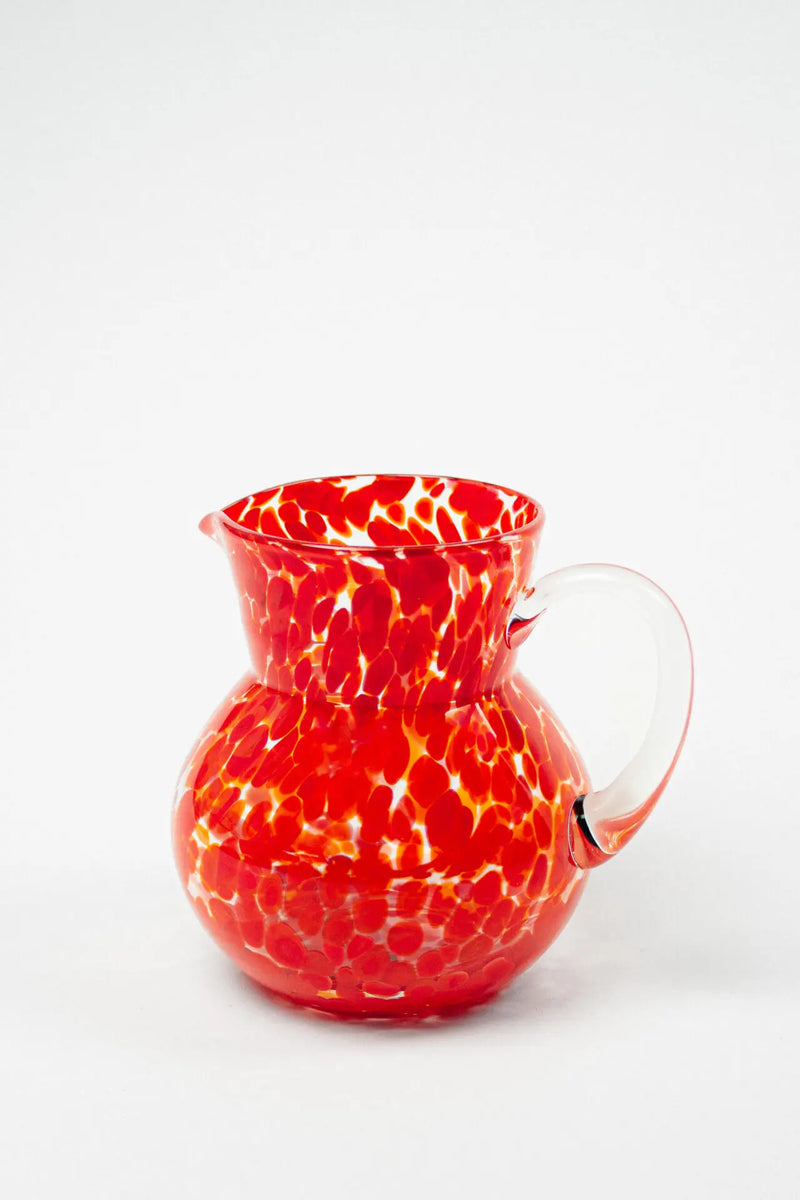 Milano red speckled hand-blown glass jug by Olsson & Jensen on a white background