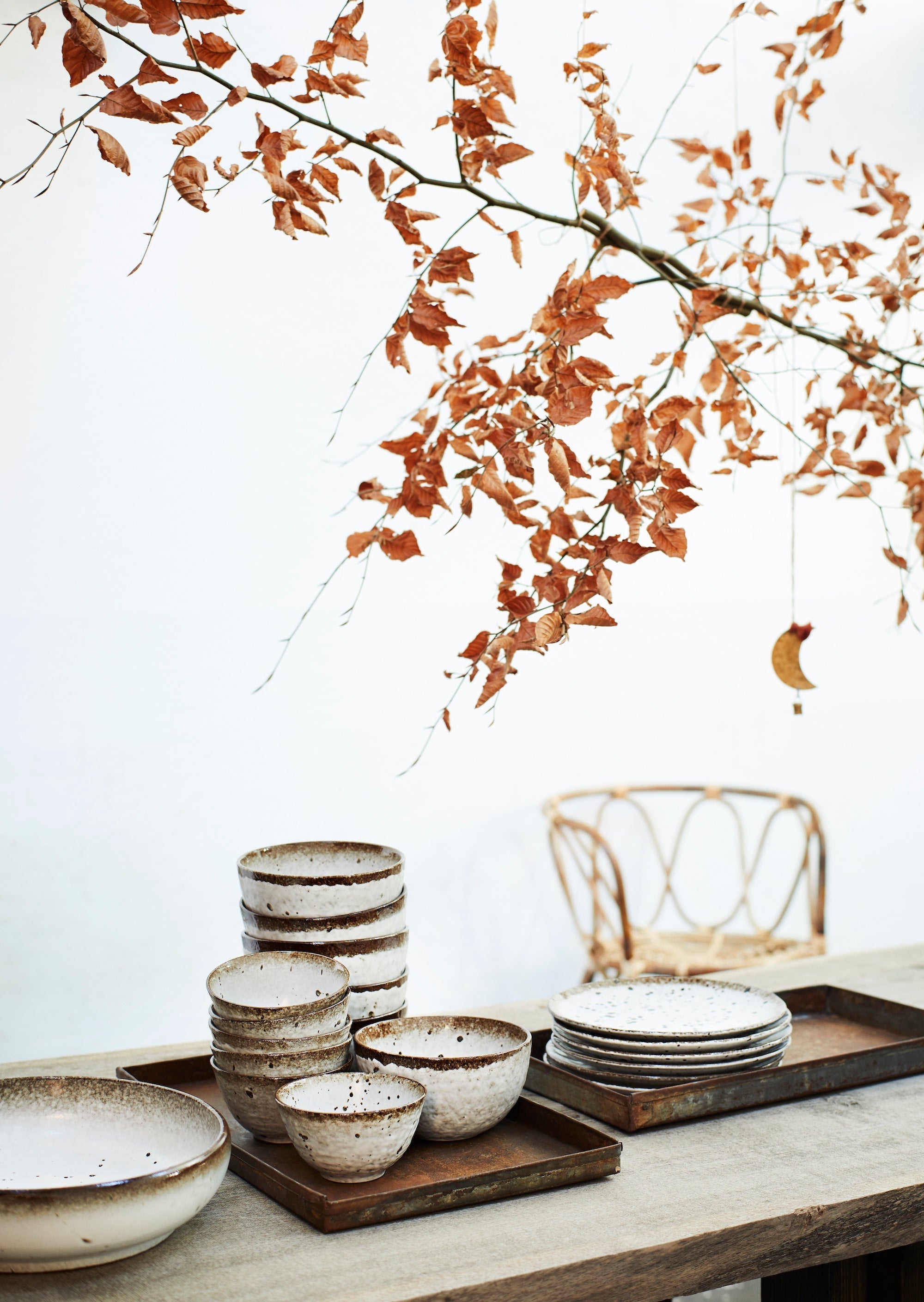 rustic Nordic table setting with stacked speckled stoneware bowls and plates

