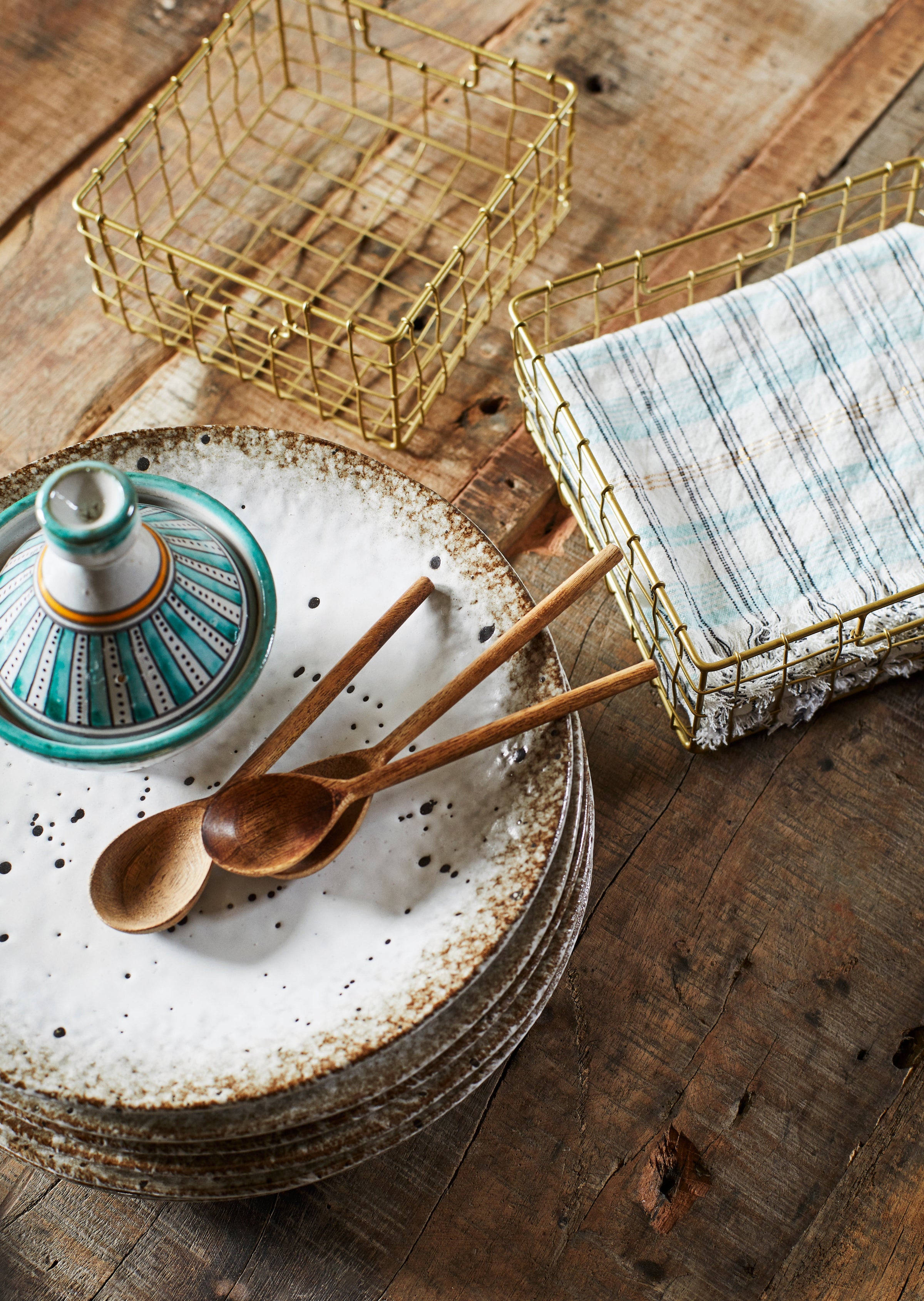 pair of small wooden spoons displayed on a speckled ceramic plate
