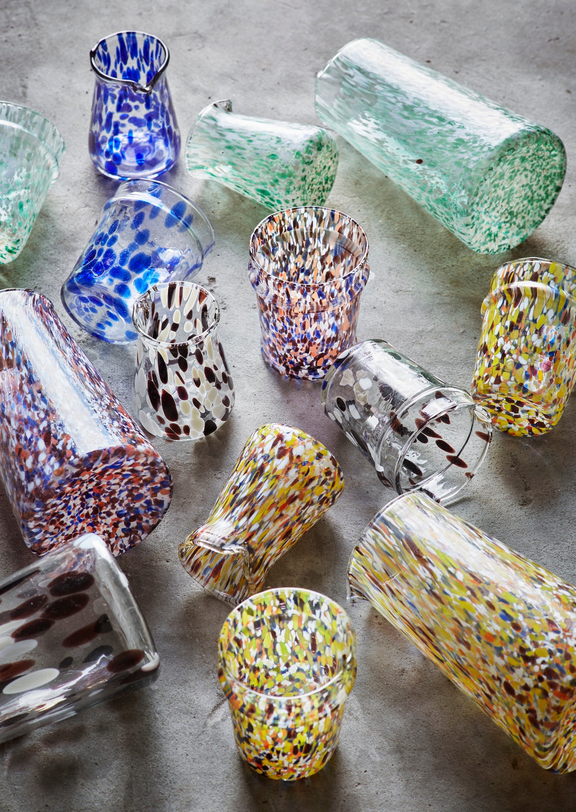 assorted handmade glass jugs and tumblers in colourful recycled glass

