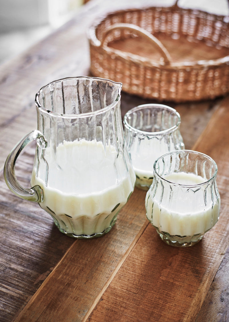 ribbed glass jug and matching drinking glasses styled on wooden table
